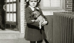 Shirley, age 5, holding a puppy in front of her home Shirley Schlanger as a child holding a puppy