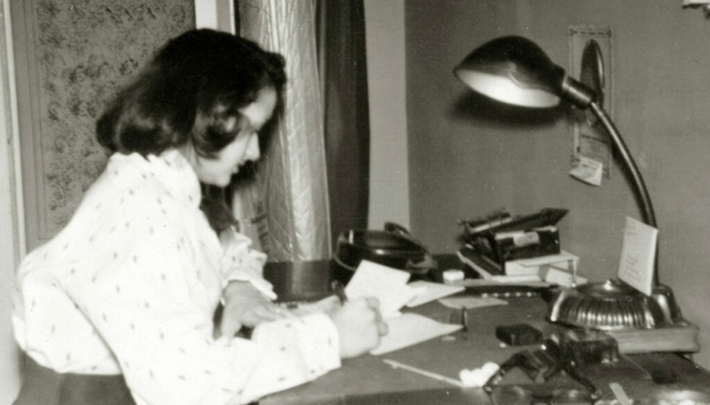 Shirley Schlanger writing at a desk